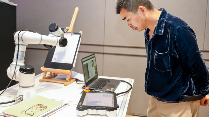 嘉賓體驗(yàn)遨博AI繪畫機(jī)器人。主辦方供圖